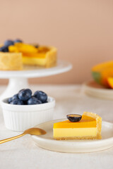 Piece of mango tart with fresh blueberry. Sugar, sugar substitutes, lactose and gluten free. Vegan dessert. Vertical orientation.