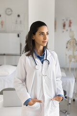 Forward thinking doctor. Pensive confident pretty young girl medical professional in white coat...