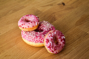 Sweet pink donut with sprinkles and strawberry topping
