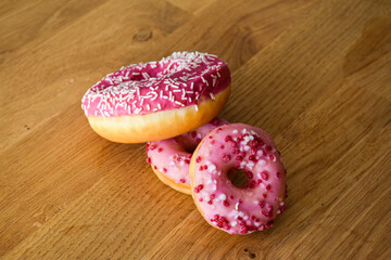 Sweet pink donut with sprinkles and strawberry topping