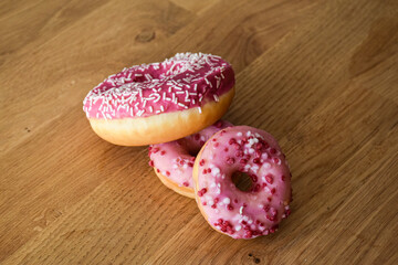 Sweet pink donut with sprinkles and strawberry topping