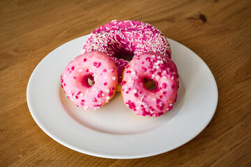 Sweet pink donut with sprinkles and strawberry topping