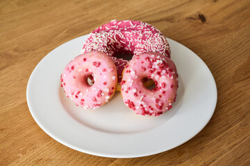 Sweet pink donut with sprinkles and strawberry topping