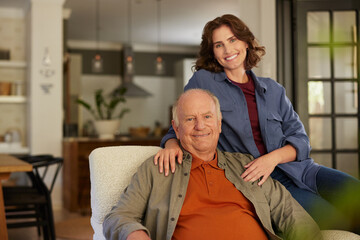 Portrait of senior father with daughter sitting on armchair