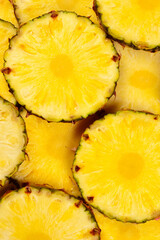 Pineapple juicy yellow slices background. Top view.