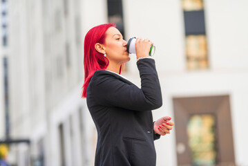 Businesswoman drinking coffee outside office building