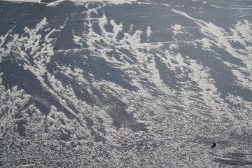 Frost and snow on frozen lake surface