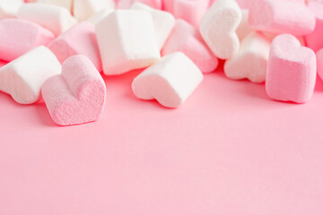 Closeup view of bunch of sweet homemade heart shape marshmallow soft jelly dessert snack made of sugar and gelatin on pink background with copy space used for greeting or celebration of valentines day