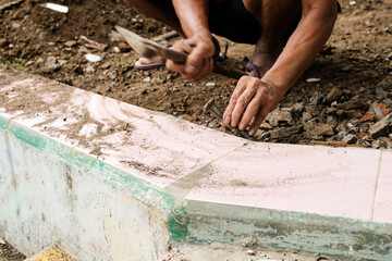 Crushing cement on the floor with chisel. A worker hits the floor with a hammer and concrete chisel...