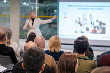 Corporate seminar session with a presenter addressing an engaged audience in a modern venue....