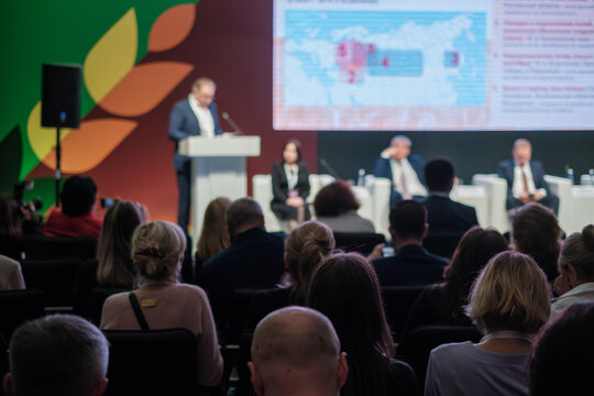 Business conference with engaged audience listening to speaker on stage. Professional presentation with dynamic visuals and expert panel discussion.