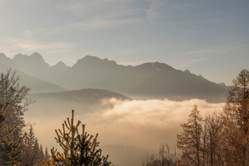 Vista panoramica di un ambiente naturale di montagna nel nord Italia con cielo sereno e nuvole basse in inverno