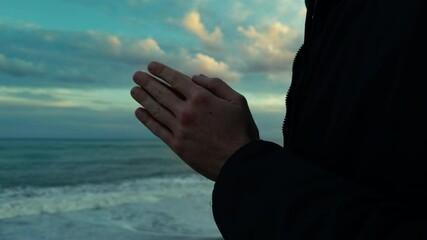 Silhouette Hands Of A Man Praying Religiously By The Stormy Ocean