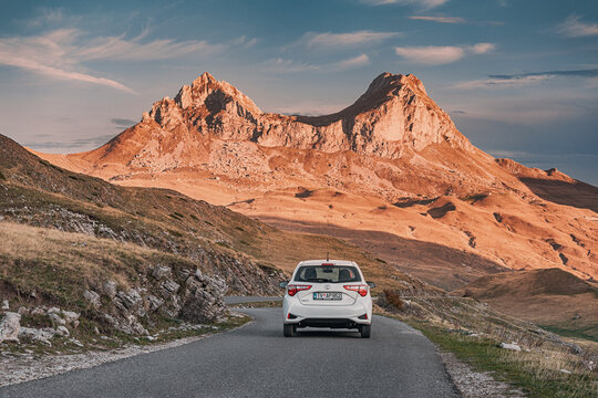 29 October 2024, Durmitor national park, Montenegro: Toyota Yaris car driving along a scenic mountain road during golden hour, offering a picturesque view of nature's beauty