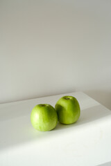 Green apples on a white table for snak, perfect for themes of healthy living and nutrition on white table.