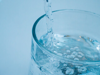 Clear water streams into a glass