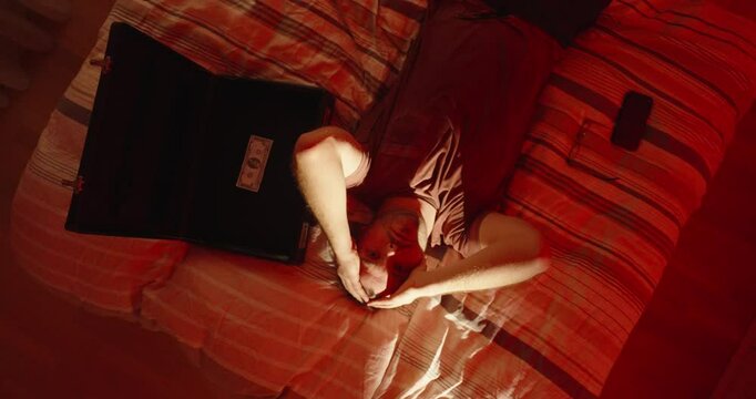 classic briefcase: a man lies on a bed with an almost empty briefcase and is emotional, filmed from above