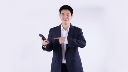 Portrait of young Asian business man using phone and posing on white background