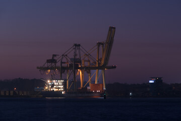 Obraz premium SEA PORT IN SWINOUJSCIE - The lighthouse and the quay of transshipment terminal at sunrise