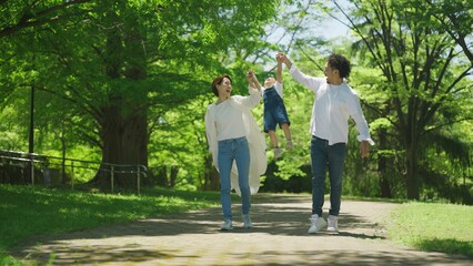 Fototapeta premium 公園で手を繋いで歩く家族