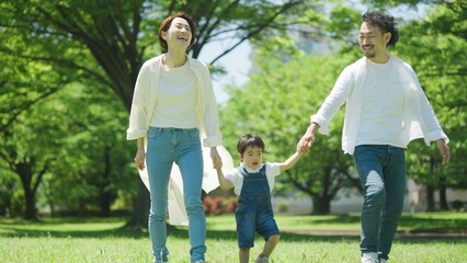 公園で手を繋いで歩く家族