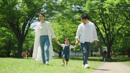 Obraz premium 公園で手を繋いで歩く家族