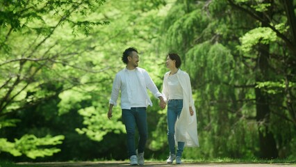 Fototapeta premium 新緑の中を歩くカップル