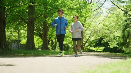 夏の早朝にジョギングする男女