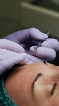 Blackheads removal procedure at cosmetologist's. Female client wearing a cap lies on the couch having face skin care. Close up. Vertical video