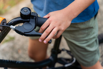 A child's hand pressed the brake lever on their bicycle