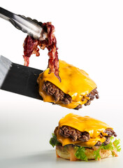 stacking up cheese burger, double juicy beef patty with melted cheddar cheese, and crispy bacon,...