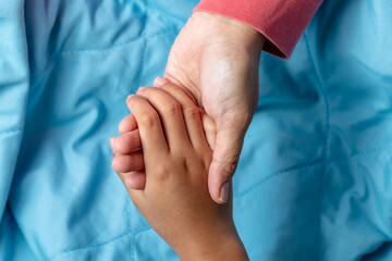 Parent Holding Child's Hands in Comfort