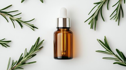 Fototapeta premium Top view of a rosemary essential oil bottle alongside vibrant green sprigs on a clean white surface, highlighting natural beauty