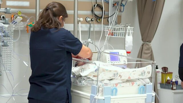 Nice shot of a nurse caring for infants in an incubator