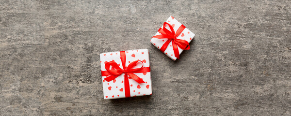Valentine day composition: red gift box with bow and heart. Christmas present. View from above....