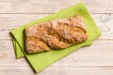 Fresh loaves of bread with wheat and gluten on a colored table. bread on napkin on rustic background, fresh bread top view