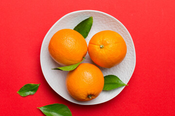 Flat lay of Fresh orange fruit with sliced in plate on Colored background. Top view with copy space