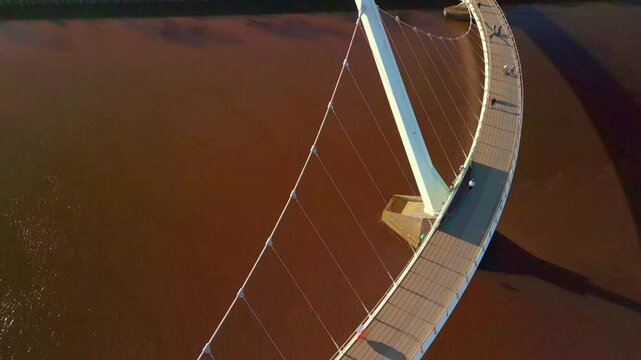 Descending aerial of the Peace Bridge in Derry-Londonderry. Filmed on a sunny day in 4K, 60 frames per second and in Rec709 color.