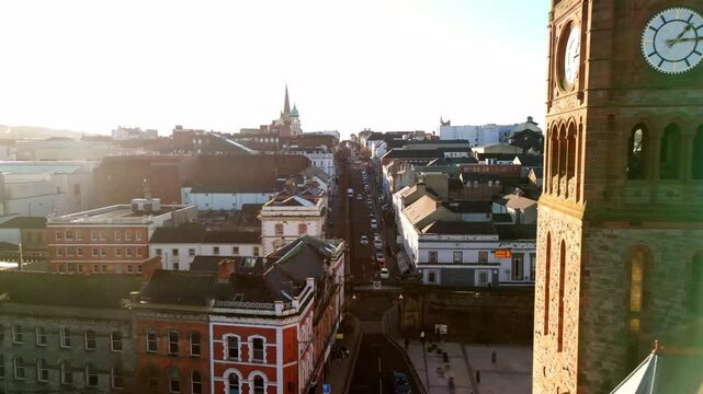 Reversing aerial of Shipquay Street and the Guildhall in Derry-Londonderry in NI. The camera reverses to reveal the sloping street and tower clock. Filmed in 4K, 60fps and in Rec709 color.