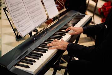 Musician performing on piano during concert in historic church setting