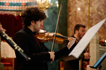 Musicians performing classical music during a concert in a church setting