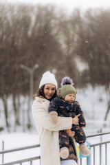 Mom and son walking in the winter. Happy mother and child enjoying the winter