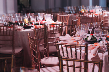 Beautiful table decoration for luxury  event in pink and gold, cutlery and tableware, banquet hall arrangement decor, celebration in restaurant with flowers, candles on a wedding reception party