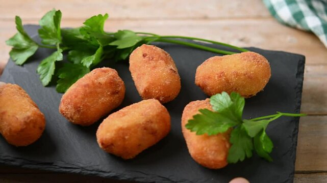 Fried cod croquettes on wooden table