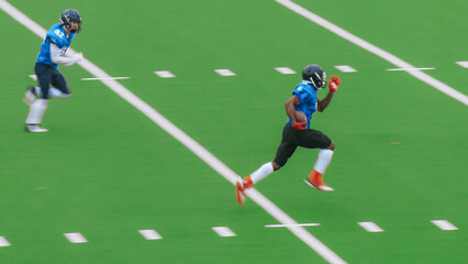 American Football Match with Diverse Male Athletes in Red and Blue Jerseys Run in a Field, Battle for the Ball. Athletic Player Runs with the Ball