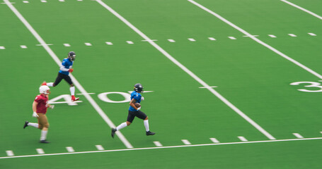 American Football Match with Diverse Male Athletes in Red and Blue Jerseys Run in a Field, Battle for the Ball. Athletic Player Runs with the Ball