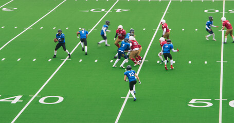 Diverse Male Athletes in Red and Blue Jerseys Compete in an American Football Game. Motivated Players Clash for Control on the Field, Dodging and Blocking Opponents