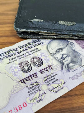Top View of Fifty rupees Indian currency note and Old Black Wallet.
