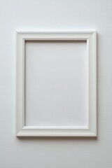 Empty white photo frame positioned against a clean white wall inviting decoration or artwork