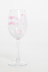Empty wine glass with lip print on white background. Vertical photo. High quality photo